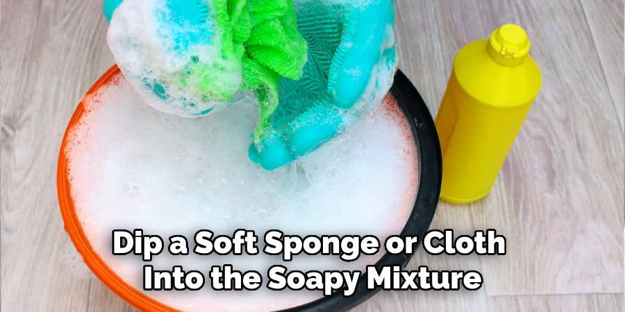 Dip a Soft Sponge or Cloth Into the Soapy Mixture