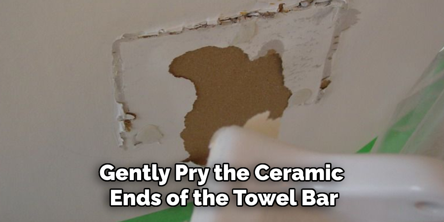 Gently Pry the Ceramic Ends of the Towel Bar